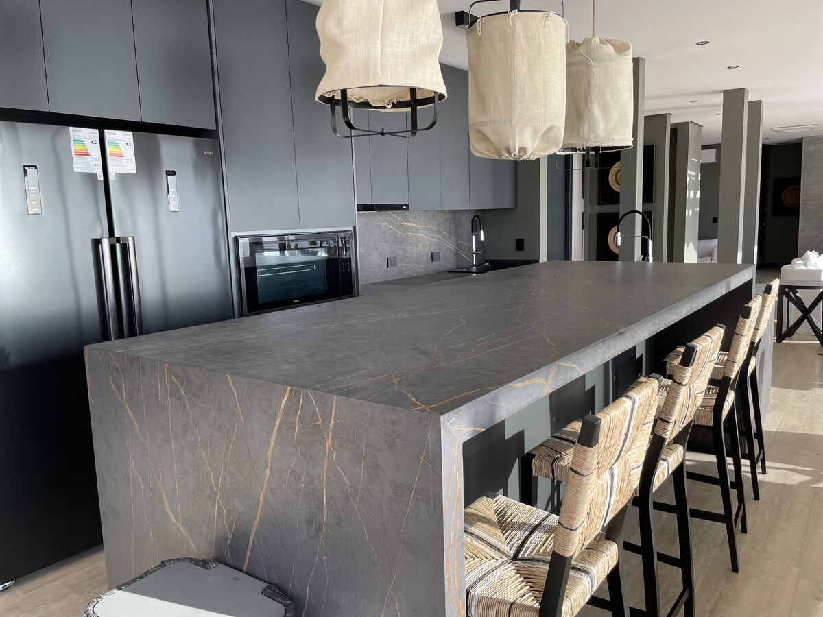 Cocina con isla de piedra y lámparas colgantes