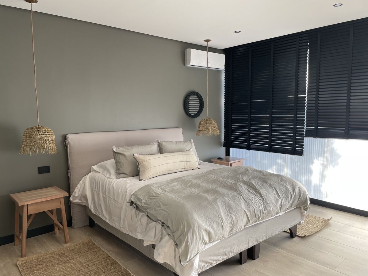 Dormitorio con cortinas de madera y cama king